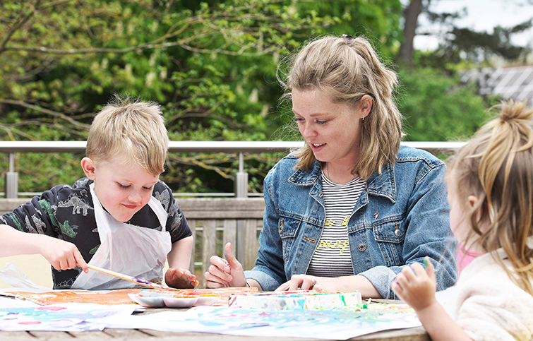 Two children and an adult painting