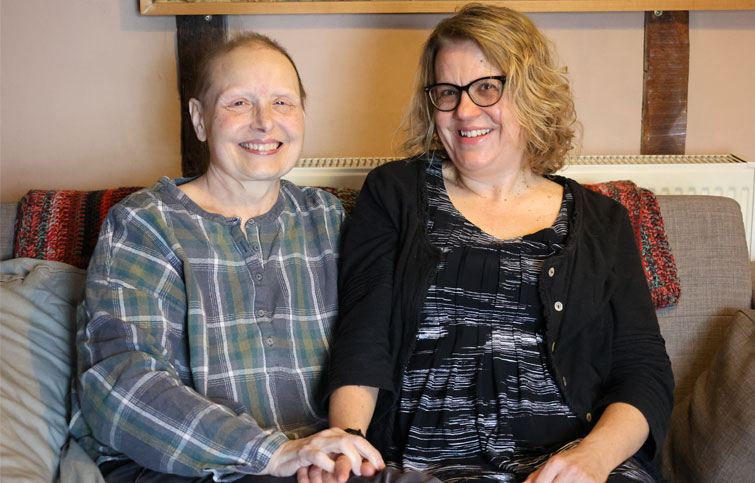 Viv and Rachel sitting together on the sofa smiling at the camera