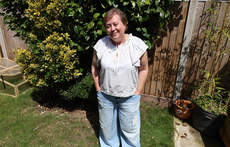 Wendy is standing in a garden smiling at the camera