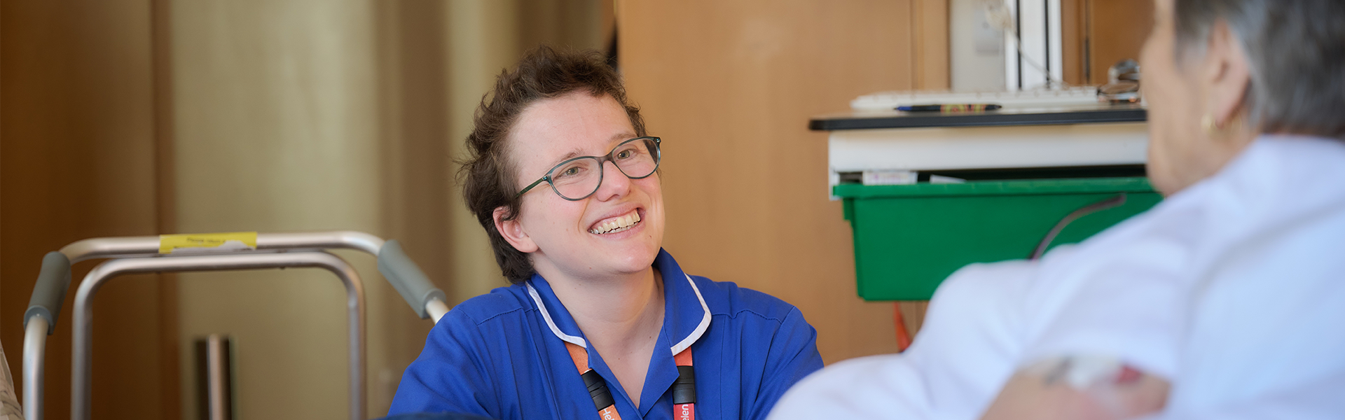A nurse smiling at a patient in a bed for respite care at St Helena Hospice