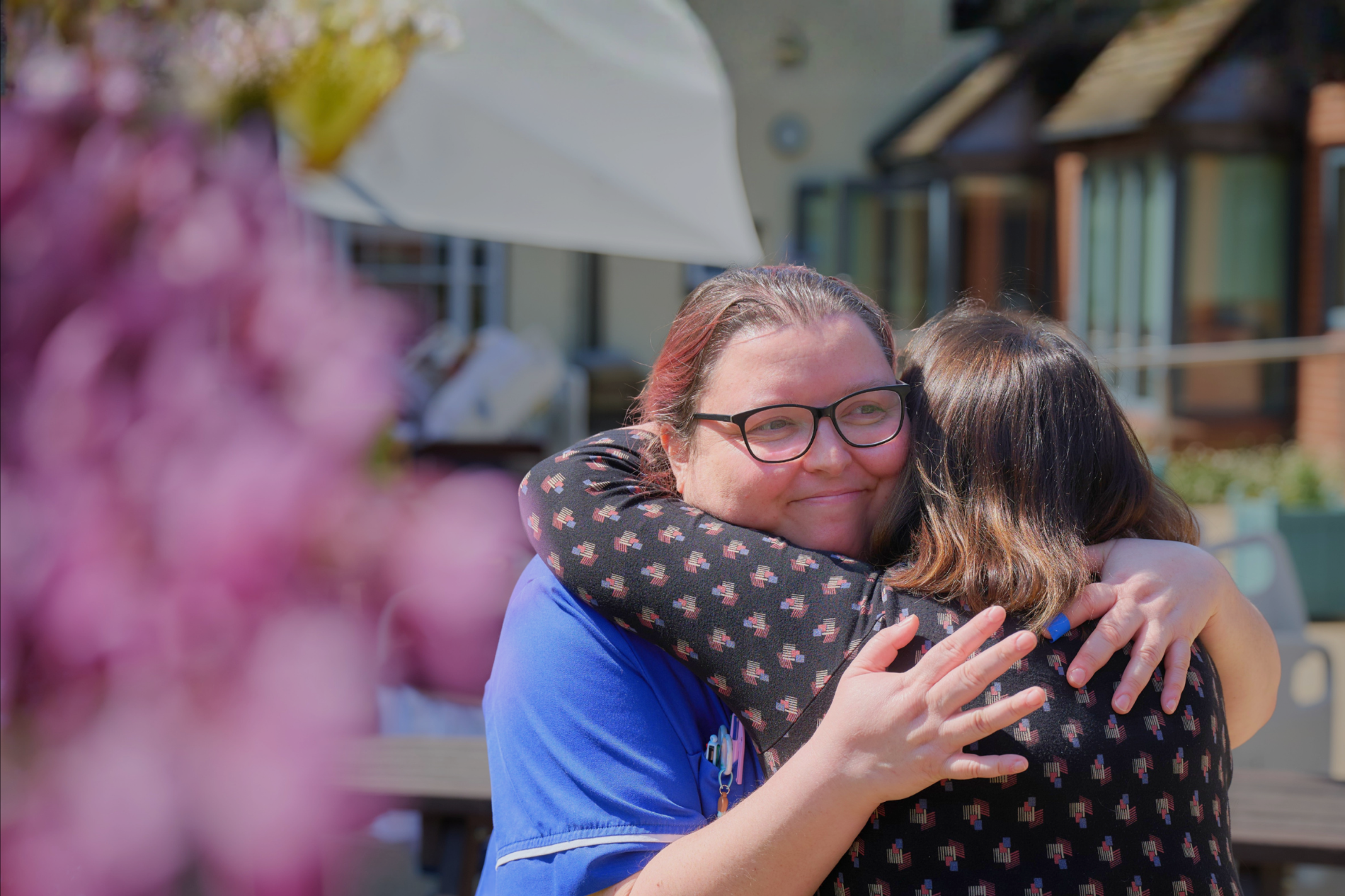 A nurse hugging somebody in the hospice garden