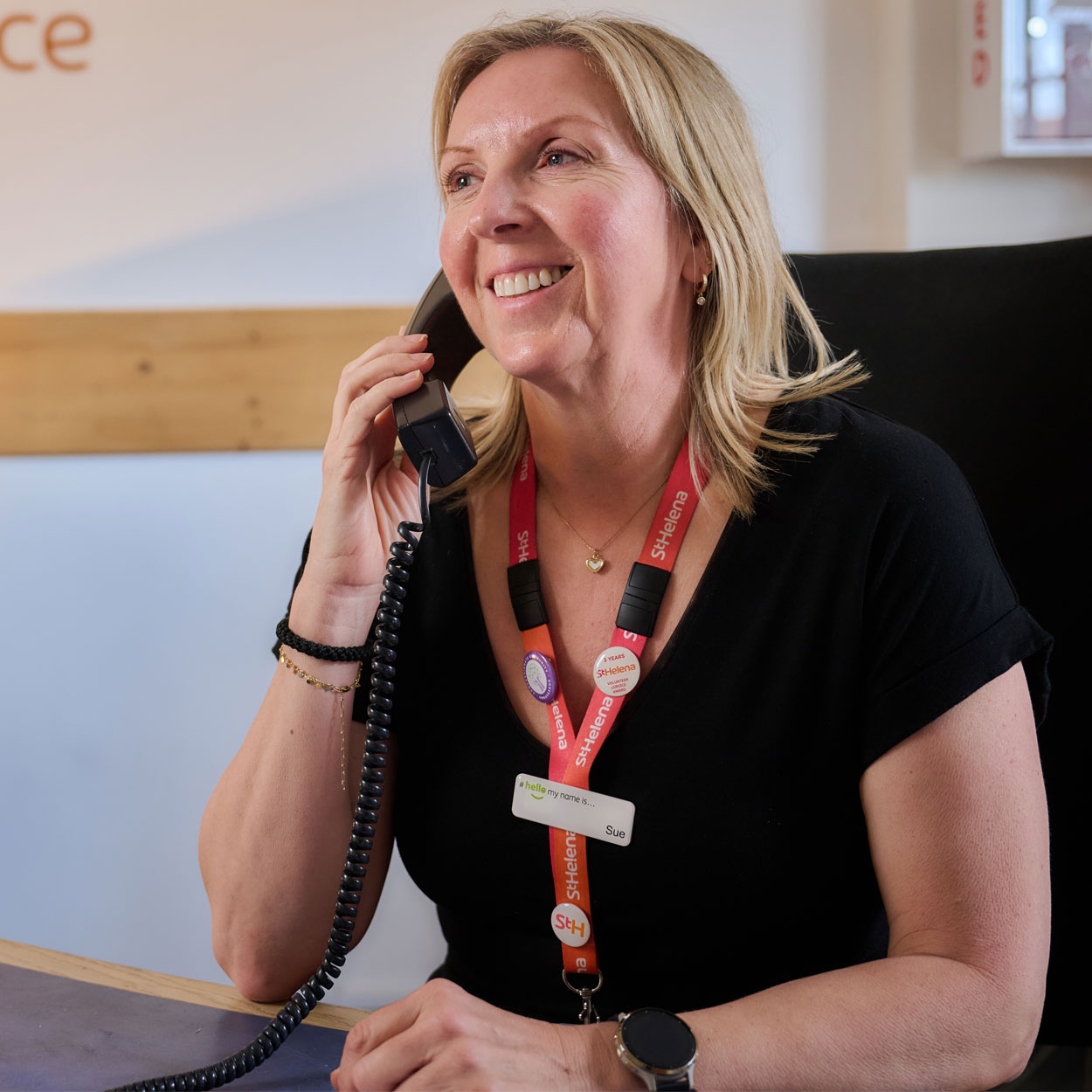 Volunteer receptionist Sue on the phone at St Helena Hospice