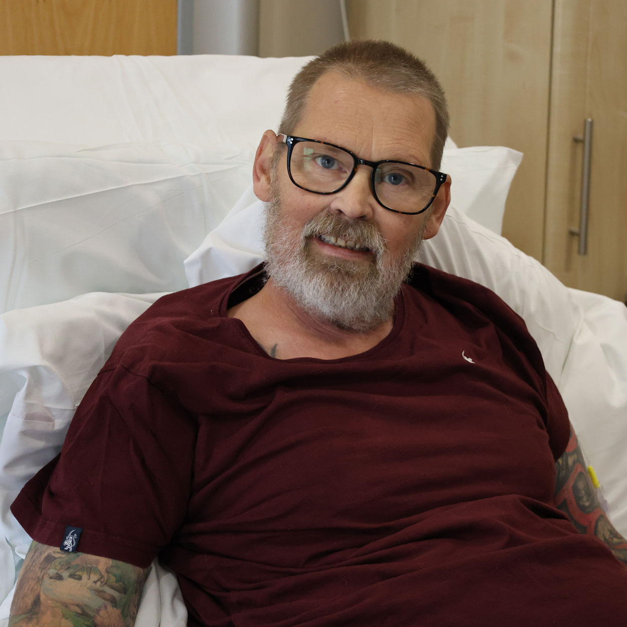 David is in his bed at St Helena Hospice and smiling at the camera